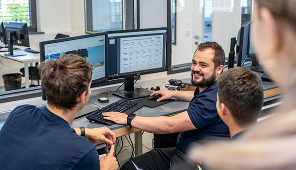 A group of trainees discussing something on two screens