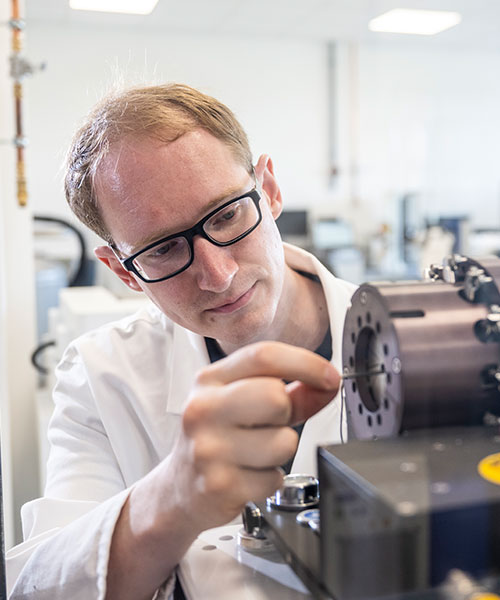 Man with glasses makes a radial force test in the test laboratory