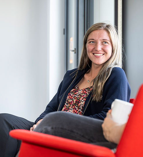 Blonde woman sitting on red armchair